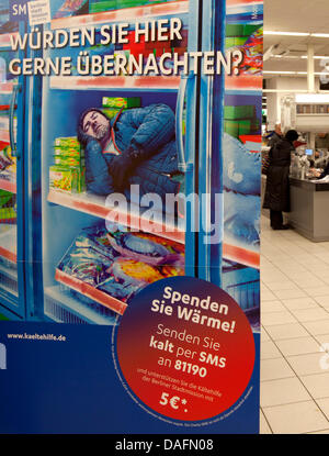 Un poster che dice 'Wuerden Sie hier gerne uebernachten?' (Vuoi dormire qui?) è messo in mostra in un supermercato a Berlino, Germania, 05 dicembre 2011. La città di Berlino la missione utilizza il poster di un uomo che stabilisce in un congelatore per chiamare per le donazioni per il sostegno delle persone senza fissa dimora. Foto: Florian Schuh Foto Stock