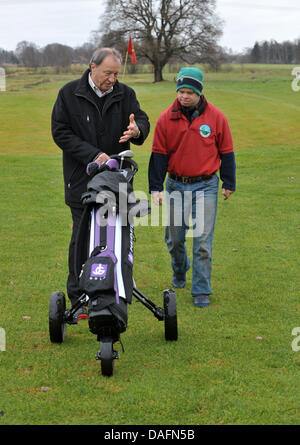 Christophe Schuler (R), il giocatore di golf con trisomia 21, e suo padre Dietrich, il club di vice-presidente, parlare a Lilienthal Golf Club a Lilienthal, Germania, 28 novembre 2011. La Lilienthal club è stato il primo a rompere con la separazione dei disabili e non i giocatori. I giocatori provenienti da tutte le generazioni giocare sotto il motto "con handicap per handicap". Foto: Carmen Jaspersen Foto Stock