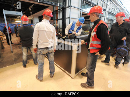 I passeggeri di test provano un controllo di sicurezza durante una prova di eseguire in futuro Berlin-Brandenburg, aeroporto di Schoenefeld, Germania, 08 dicembre 2011. Dal check-in attraverso i controlli di sicurezza, i dipendenti della compagnia aerea, i funzionari di polizia e i dipendenti Globeground assistere alla prova al futuro aeroporto di BER. Non appena il Willy-Brandt-Airport sarà aperta il 03 giugno 2012, 27 milioni di passeggeri per voi Foto Stock