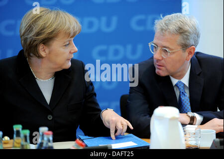 Il cancelliere tedesco Angela Merkel parla al Ministro tedesco per l'ambiente e la sicurezza nucleare Norbert Roettgen durante la riunione del Consiglio federale di cristiano-democratici (CDU) alla Konrad-Adenauer-House a Berlino, Germania, 12 dicembre 2011. Foto: RAINER JENSEN Foto Stock