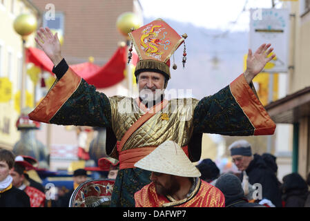 Ein als verkleideter Cinese Mann winkt am Donnerstag (03.03.2011) während dem Chinesenfaschingsumzug traditionellen a Dietfurt (Oberpfalz). Wie jedes Jahr am 'Unsinnigen Donnerstag' ziehen als Asiaten verkleidete Narren durch den Ort. Der Chinesenfasching geht auf eine Sage zurück, wonach die Dietfurter im Mittelalter einen Steuereintreiber einfach vor der Stadtmauer stehen ließe Foto Stock