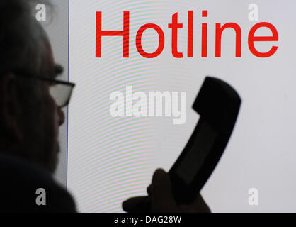 Un file immagine scattata il 6 ottobre 2010 mostra un uomo con un telefono nella parte anteriore di una "Hotline" didascalia in Straubing, Germania. Nel corso di una riunione tenuta il 2 marzo, il Cabinet hanno discusso i progetti per rendere il telefono hotline chargefree. Foto: Armin Weigel Foto Stock