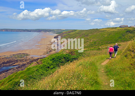 La gente che camminava sul sentiero costiero sopra Newgale Beach, Regno Unito, Galles Pembrokeshire Foto Stock