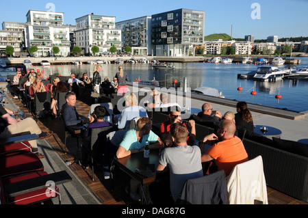 Città sostenibile lo sviluppo a Hammarby Sjöstad a Stoccolma con ristoranti sul lungomare, imbarcazioni, appartamenti e passaggi pedonali. Foto Stock