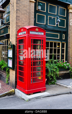 Red cabina telefonica accanto a un pub Foto Stock