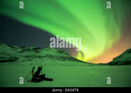 Aurora tenda davanti al cielo stellato sulla neve nella valle con un fotografo di natura delle attrezzature del nella neve, Norvegia, Troms, Kvaloea, Kattfjordeidet Foto Stock