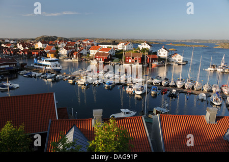 Piccolo porto pieno di barche e yacht, e case colorate sulla isola di Gullholmen in Bohuslän sulla costa occidentale della Svezia Foto Stock