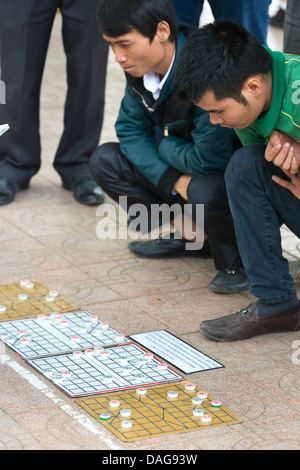 Gli uomini la riproduzione di un gioco di bordo per le strade di Hanoi, Vietnam Foto Stock