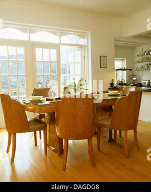 Anni Trenta tavolo e sedie imbottite con legno di noce schienali in cucina moderna sala da pranzo con parquet Foto Stock