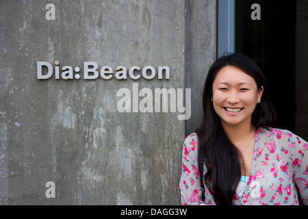 Ragazza asiatica sorride accanto al segno annunciando la dia:Beacon contemporary art institute nella Hudson Valley al Beacon, NY, STATI UNITI D'AMERICA. Foto Stock