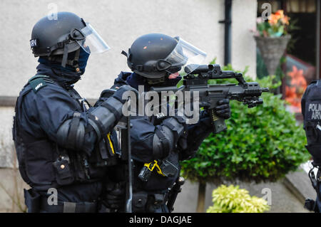 Belfast, Irlanda del Nord, 12 Luglio 2013 - UN PSNI officer dall'unità ARV indossa un casco balistica mira a Heckler & Koch G36C fucile da assalto. Il suo collega detiene una ballistic scudo protettivo Credit: stephen Barnes/Alamy Live News Foto Stock