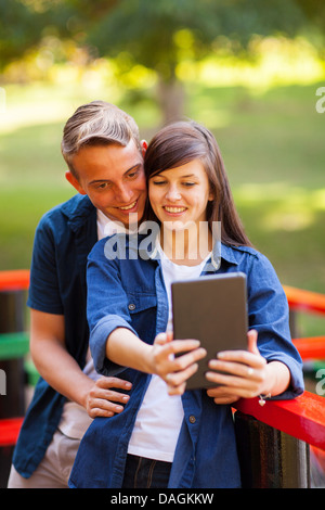 Carino giovane adolescente tenendo ritratto di auto all'aperto Foto Stock