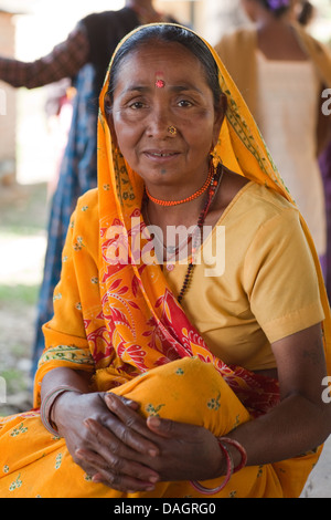Anziani Tharu donna in un incontro di comunità hall. Bardia. Zona di Bheri, Regione Mid-Western, Terai. Il Nepal. Nota dress tilak fronte Foto Stock