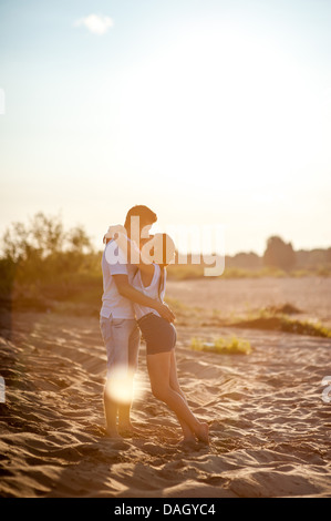 Matura in amore passeggiate sulle rive del fiume in denim shorts e camicie bianche. Foto Stock