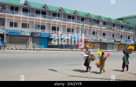 Srinagar, Indiano Kashmir amministrato del 13 luglio 2013. I fornitori indiani a piedi durante uno sciopero e restrizioni a Srinagar, Jammu e Kashmir in India. Le autorità indiane distribuito migliaia di truppe in Kashmir per prevenire le proteste sulla luglio 13 il quale è contrassegnato come "martiri" Giorno", che segna il Maharaja Hari Singh di uso della forza in 1931 per sedare la protesta contro la sua regola, causando la morte di 23 musulmani. (Sofi Suhail/ Alamy Live News) Foto Stock