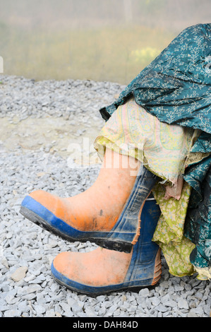 Arancio e blu puntale in acciaio tappate chainsaw protettivo stivali di sicurezza indossato con seta colorata gonne, Wales, Regno Unito Foto Stock