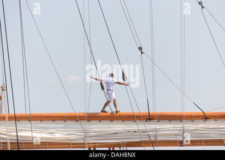 Un deck passeggiate a mano sui principali gaff spar su 196 piedi di yacht a vela Germania Nova come vele porto di Charleston Giugno 26, 2013 a Charleston, Carolina del Sud. Foto Stock