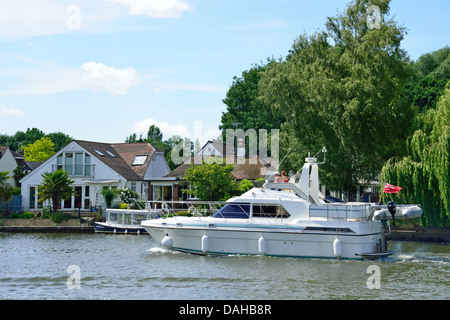 Tempo libero barca passando riverside Case sul fiume Tamigi, Walton-on-Thames, Surrey, England, Regno Unito Foto Stock