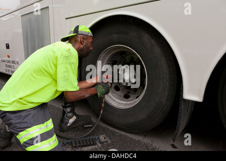 Rimozione meccanica di un bus ruota con una chiave a percussione Foto Stock