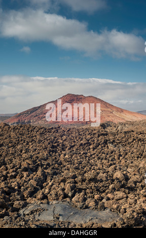 AA flussi di lava con una piccola area di lava pahoehoe nera in primo piano, con Montana Bermeja, un giovane cono vulcanico ossidato sullo sfondo Foto Stock