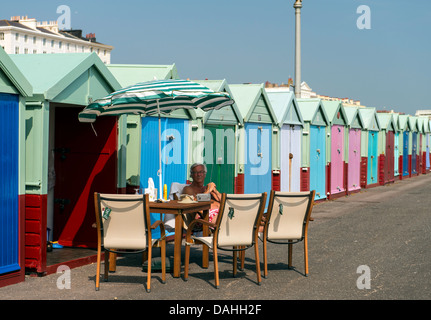 Il vecchio uomo crogiolarsi al sole in spiaggia capanne in Brighton Inghilterra Gran Bretagna REGNO UNITO Foto Stock