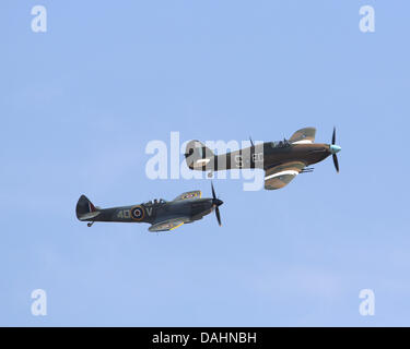 Duxford, UK. 13 Luglio, 2013. L'ultimo Hawker Hurricane mai costruito (14,533), PZ865 rotolare la Hawker linea di produzione a Langley, Bucks, nel luglio 1944 con la scritta "l'ultimo dei tanti' sul suo babordo e tribordo i lati. Il velivolo è ora parte del RAF Battle of Britain Memorial e il volo è visto qui volare con BBMF Spitfire Mk XVIE Credito: Niall Ferguson/Alamy Live News Foto Stock