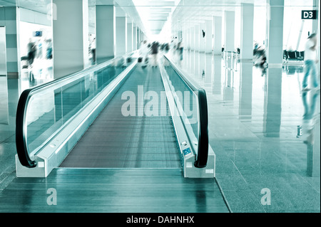 Concetto di viaggio. Escalator all'interno moderno aeroporto terminale. Immagine in colori blu con sfocatura Foto Stock