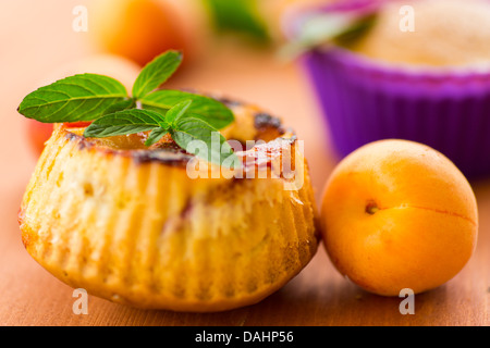 Muffin con albicocche e menta su una tavola di legno Foto Stock