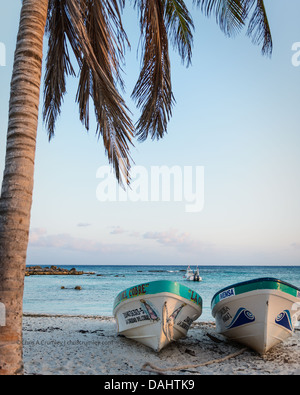 Due barche su una spiaggia al tramonto in Cozumel, Messico Foto Stock