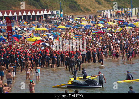 Bournemouth, Regno Unito 14 luglio 2013. British Heart Foundation molo di Bournemouth Pier nuotare, il più grande carità nuotare in Europa come sostenitori coraggiosi il canale in inglese in questo 1.4 miglio open water swim, partendo dal molo di Bournemouth nuotatori sono messi alla prova in questa impegnativa mare che nuotano lungo il litorale di Boscombe Pier. Nuotatori prendere al mare nella soffocante temperature, nonché evitando di masse di visitatori in mare, sperando di sollevare £180.000 per la carità. Ci si aspetta che siano circa 1.200 al mezzogiorno di partenza, la seconda delle nuotate. Credito: Carolyn Jenkins/Alamy Live News Foto Stock