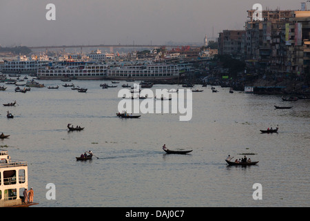 Merci e passeggeri al crepuscolo andando a e da Sadarghat e il fiume Buriganga che attraversa il cuore di Dacca in Bangladesh Foto Stock