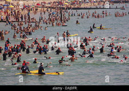 Bournemouth, Regno Unito 14 luglio 2013. British Heart Foundation molo di Bournemouth Pier nuotare, il più grande carità nuotare in Europa come sostenitori coraggiosi il canale in inglese in questo 1.4 miglio open water swim, partendo dal molo di Bournemouth nuotatori sono messi alla prova in questa impegnativa mare che nuotano lungo il litorale di Boscombe Pier. Nuotatori prendere al mare nella soffocante temperature, nonché evitando di masse di visitatori in mare, sperando di sollevare £180.000 per la carità. Ci si aspetta che siano circa 1.200 al mezzogiorno di partenza, la seconda delle nuotate. Credito: Carolyn Jenkins/Alamy Live News Foto Stock