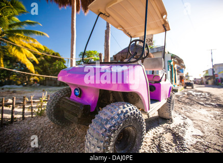 Funny pink golf auto in strada su un isola tropicale Foto Stock