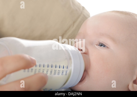 Madre che nutre il suo bambino con una bottiglia di latte Foto Stock