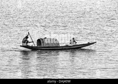 Gli uomini remare una barca di legno lungo il fiume Hugli, Calcutta, West Bengal, India Foto Stock