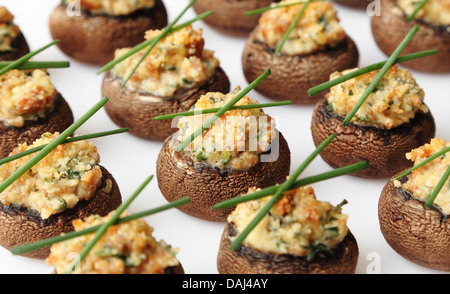 Funghi ripieni - cotto dei tappi a fungo farcito con salsiccia e formaggio e spezie. Foto Stock