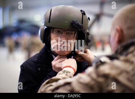 Verteidigungsminister Thomas de Maiziere (CDU, M) trägt am Sonntag (27.03.2011) vor einem Hubschrauberflug von Masarè-i-Scharif nach Kundus einen Pilotenhelm. Bei einer zweitägigen Reise nach Afghanistan besucht de Maiziere erstmals nach seinem Amtsantritt als die Verteidigungsminister Bundeswehrsoldaten in Afghanistan. Foto: Michael Kappeler dpa Foto Stock