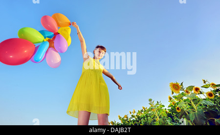 Ragazza che gioca con palloncini in estate Foto Stock