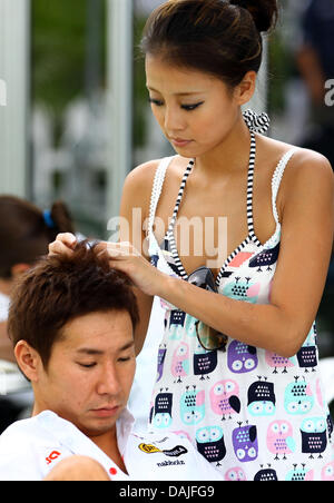 Giapponese di Formula Uno pilota Kamui Kobayashi della Sauber e la sua ragazza visto nel paddock prima della Formula Uno il Gran Premio della Malesia sul circuito di Sepang, al di fuori di Kuala Lumpur, Malesia, 10 aprile 2011. Foto: Jens Buettner dpa Foto Stock