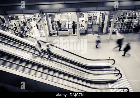 Una fotografia in bianco e nero di passeggeri a piedi giù per una scala mobile al rali Cross St Pancras International Station di Londra, unite Foto Stock