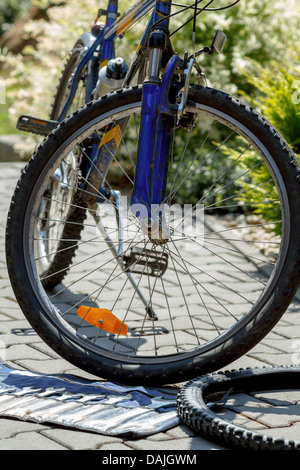 La riparazione di biciclette, prepararsi a cambiare pneumatico vecchio con strumenti, sfondo sfocato Foto Stock
