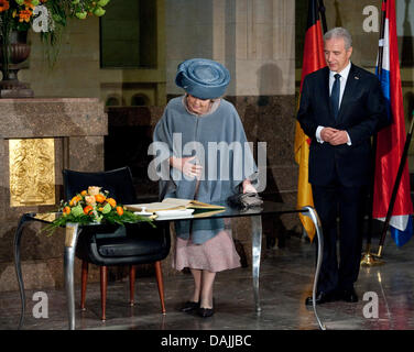 La regina Beatrice dei Paesi Bassi segni il suo nome nella golden guestbook sassone mentre il primo ministro Stansilaw Willich guarda su durante una visita alla Cancelleria di Stato a Dresda, in Germania, il 14 aprile 2011. La famiglia reale olandese è su una quattro giorni di visita in Germania. Foto: ROBERT SCHLESINGER Foto Stock