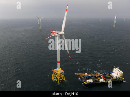 (Dpa) File - Un archivio foto, datata 12 novembre 2009, mostra un armamento recipiente successivo ancoraggio ad una turbina eolica in Germania,s prima energia eolica offshore parco vicino l'isola di Borkum, Germania. Foto: Ingo Wagner Foto Stock