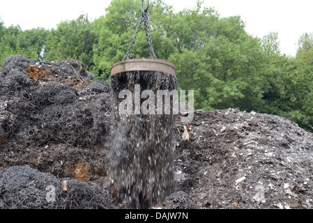 Afferrare magnetico sulla gru di sollevamento rottami di metallo a scrapyard regno unito Foto Stock