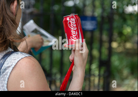Una lattina di Coca Cola detenute da una ragazza. Foto Stock