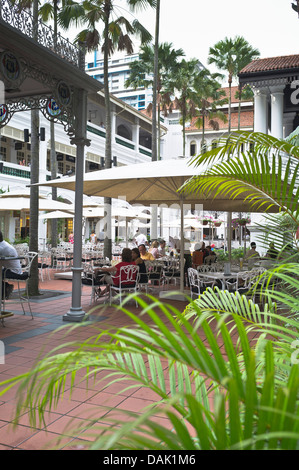 Dh Raffles ristorante courtyard RAFFLES HOTEL SINGAPORE gente seduta fuori mangiare e bere Foto Stock