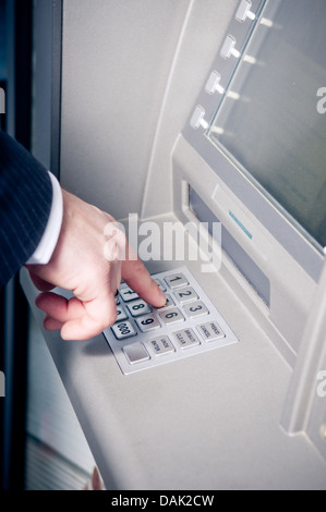 Imprenditore tramite bancomat per prelevare contanti Foto Stock