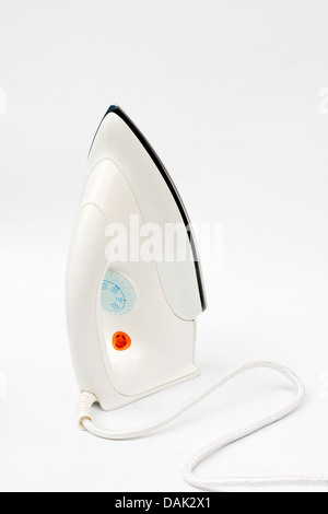 Pila di abiti colorati e ferro da stiro elettrico su sfondo bianco Foto Stock