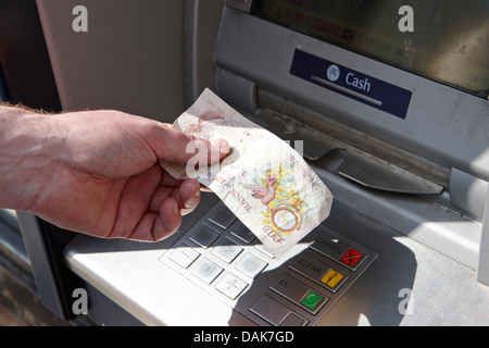 uomo che gestisce un bancomat che ritira banconote da dieci sterline londra, inghilterra regno unito Foto Stock