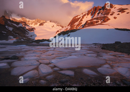 Laguna de los Tres con ice floes nella luce del mattino; Fitz Roy coperto di nuvole, Argentina, Patagonia, Ande, parco nazionale Los Glaciares Foto Stock